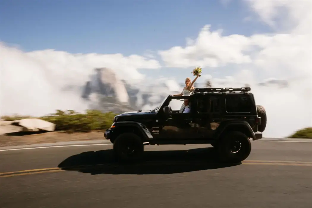 Bride in Jeep sunroof while driving through Yosemite
